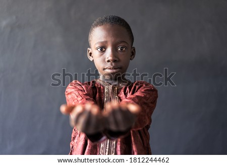 Poverty in Africa: Handsome Little African Boy Showing Hands as a Food Request