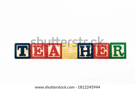 Wooden alphabet blocks spelling out the word Teacher, isolated on white background.