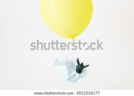 A funny donkey flies in a balloon from a medical mask. Traveler.