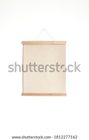 Blank paper canvas sheet poster on white wall. Mockup with copy space. Art / picture / painting concept