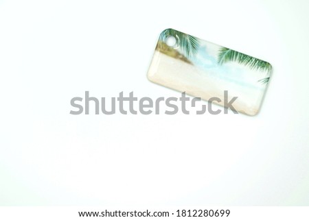 access card, glossy keychain on a white background, with a pattern of the beach with palm leaves and a blue sky, for access to protected premises under a lock and key, with a place for an inscription