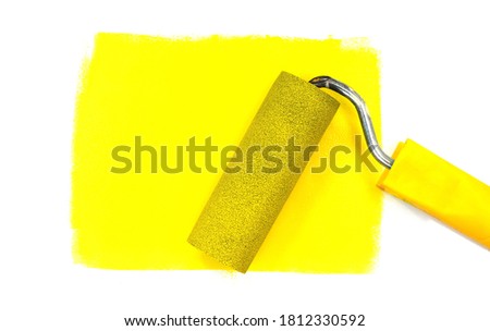 Paint roller leaving stroke of yellow  color over a white background. usable for text and messages.