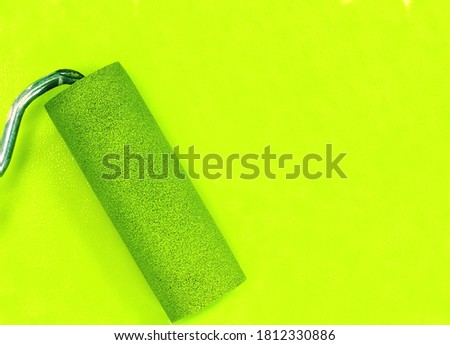Paint roller leaving stroke of green  color over a white background. usable for text and messages.