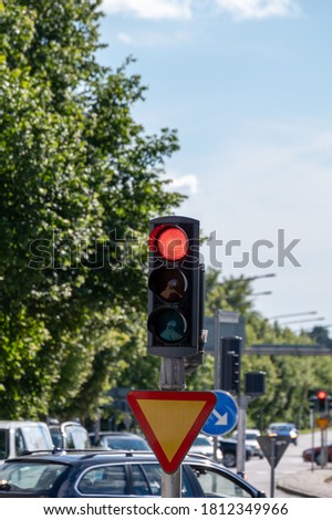 A red stop light with car congestion visible in the background