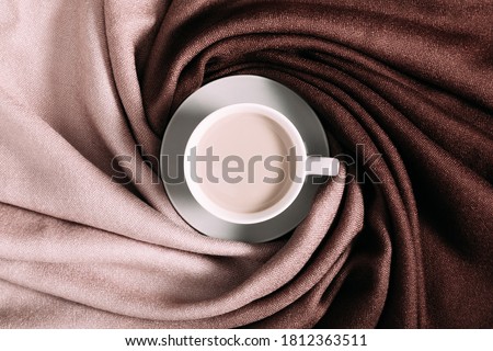 Autumn background. Beautiful elegant brown scarf and cup of coffee. Flat lay, top view