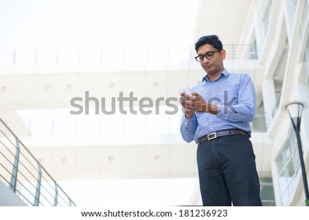 indian business man texting or surfing on a phone