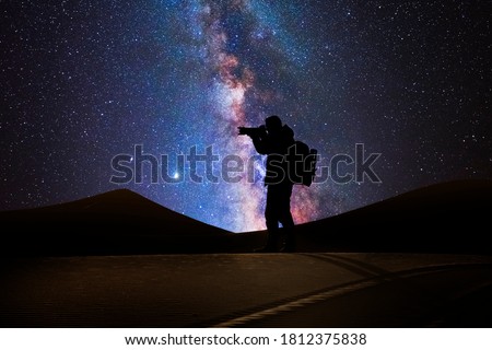 Photographer in the desert with the milky way in the background