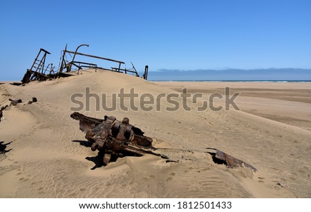 A shipwreck rusting away in the Namib Desert while the sand also covers it Royalty-Free Stock Photo #1812501433