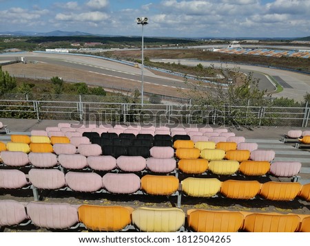 Orange, blue and yellow empty stadium seats in the stadium