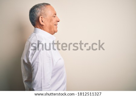 Senior handsome businessman wearing elegant shirt standing over isolated pink background looking to side, relax profile pose with natural face with confident smile.