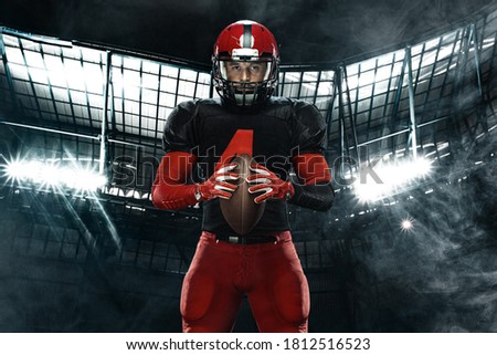 American football player, athlete sportsman in red helmet on stadium background. Sport and motivation wallpaper.
