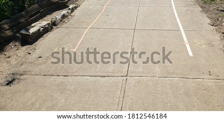 Tape and sidewalk chalk marks on a New York Sidewalk to help social distance during a farmer's market.