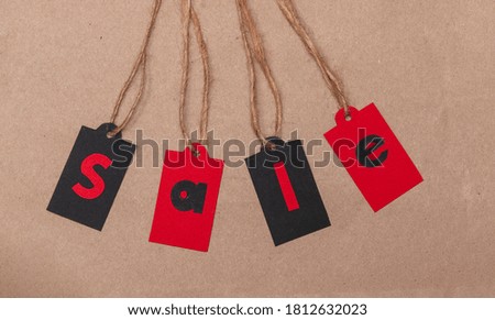 
Red and black labels on sale rope isolated on old paper texture. Banner with place for text