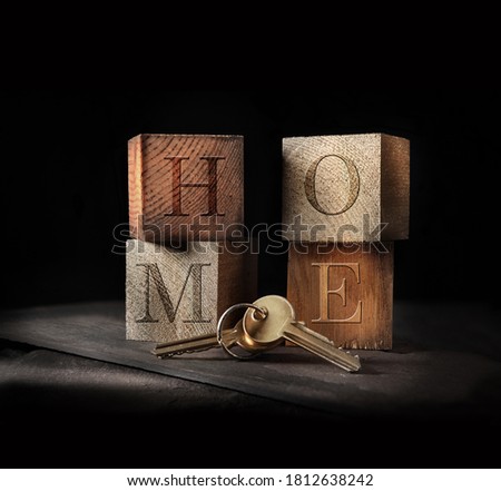 Original concept image for home buying. Rustic, creatively lit wooden blocks and golden keys to signify a home purchase with generous accommodation for copy space.