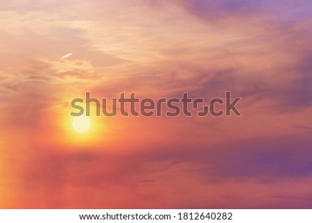 View of the bright orange halo of the sun in the evening sky at sunset. Landscape concept, background.