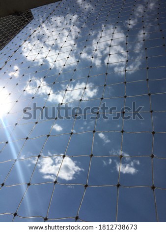 Clear blue sky with sun rays penetrating bird net