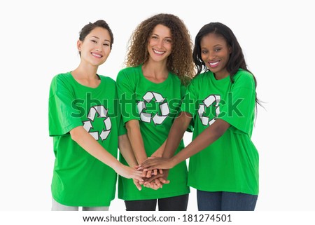 Team of environmental activists smiling at camera with hands together on white background