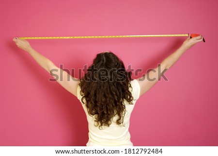 Woman with a measuring tape. Conceptual image shot Royalty-Free Stock Photo #1812792484