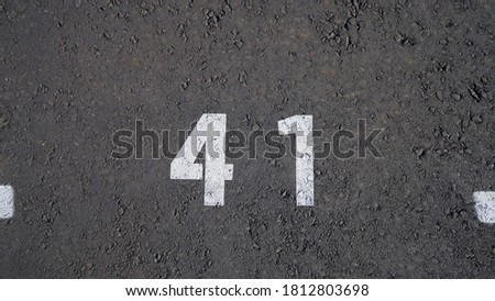 Close-up of a white paint number marking in a parking lot. Empty parking lot, Parking lot with white mark, Open parking in public park. Number 41, top view