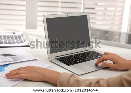 Woman working on project with solar panels at table in office, closeup