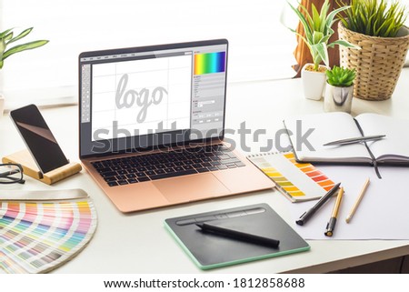 Graphic design studio with logo design on laptop screen