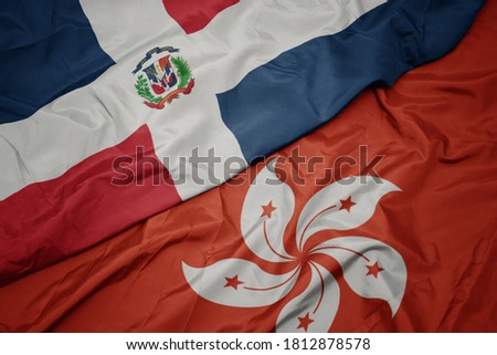 waving colorful flag of hong kong and national flag of dominican republic. macro