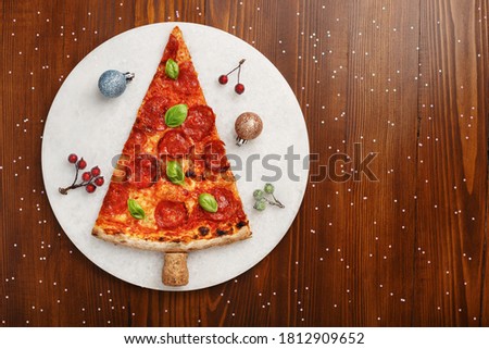 Christmas pepperoni pizza with Christmas decorations. Copy space. Top view. Royalty-Free Stock Photo #1812909652