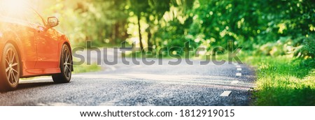 red car on asphalt road in summer Royalty-Free Stock Photo #1812919015