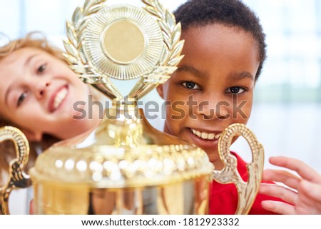 African boy holds the winner cup after a competition in school sport