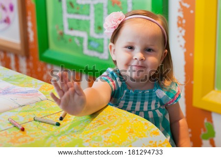 little girl smiling and waving to handle. selective focus