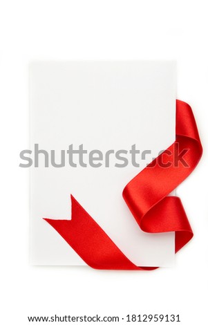Close up of a note card with ribbon bow on white background. Top view.