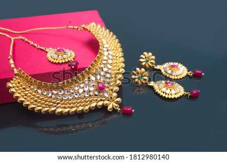 Indian Traditional Jewellery with earring, mangteeka and beautiful  box on black background. selective focus Royalty-Free Stock Photo #1812980140