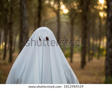 man dressed as ghost in a forest celebrating halloween