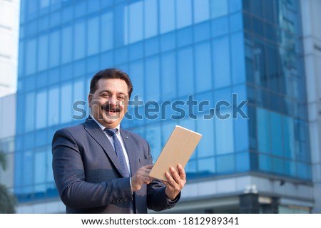 Indian businessman using digital tablet in city