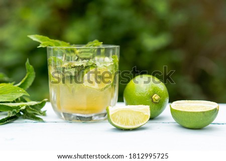 A glass of lemonade or a Mojito cocktail with lime and mint, a cold refreshing drink or a drink with ice. Summer concept. Cold detox water, copy space