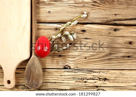 wooden spoon and one red egg on desk 