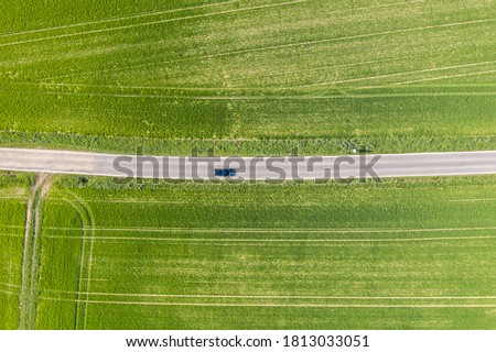 Aerial drone view, Country road runs through agricultural landscape near Walzbachtal-Johlingen in the Kraichgau in Germany