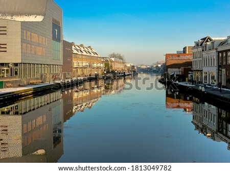 The river Rhine is flowing through the town Alphen aan den Rijn. In this photo the reflection is visible. The town is in the province Zuid-Holland.