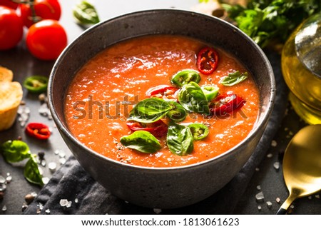 Tomato soup or gazpacho at black table. Summer cold vegan food. Royalty-Free Stock Photo #1813061623