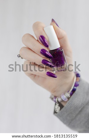 Woman hands with long nails with violet purple nail polish