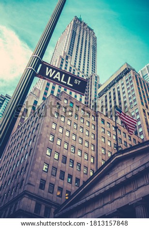 A Sign For Wall Street In Lower Manhattan, New York, With Skyscrapers Towering Behind