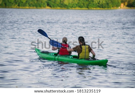 Couple paddling a kayak in the river at daytime 