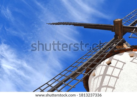 Windmill blades in Campo de Criptana with intense blue sky and clouds. Artistic photo.