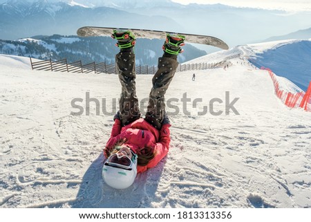 Picture of happy young lady snowboarder on the slopes