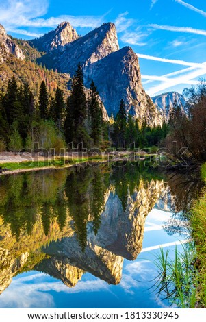 Early morning shot of the three brothers mountain range in Yosemite National Park in California taken in the Summer with reflections in the river bed below