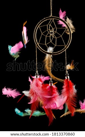 Beautiful dream catcher with flying feathers on a black background