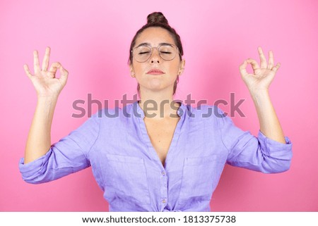 Young beautiful woman wearing glasses over isolated pink background relax and smiling with eyes closed doing meditation gesture with fingers