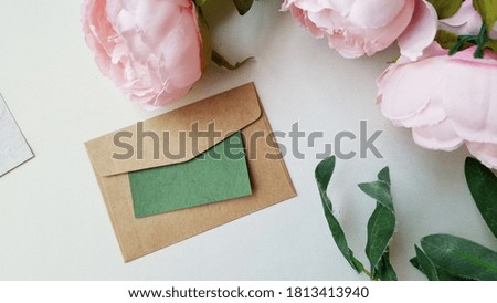kraft envelop  and  pink flower  on light background