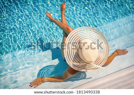 woman sitting on the stairs of a luxury five stars  spa resort  swimming pool.  Royalty-Free Stock Photo #1813490338