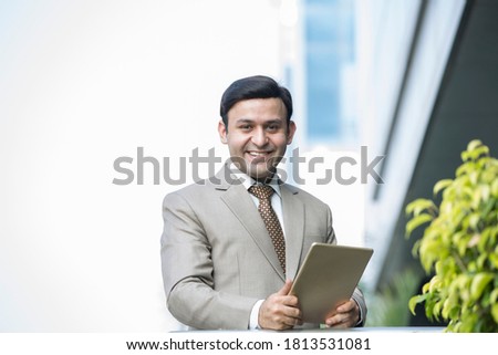 Businessman holding digital tablet outdoors
